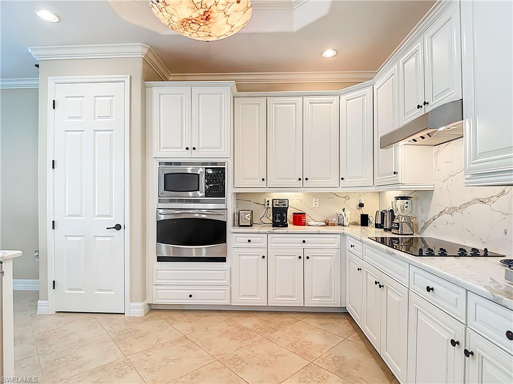 9250 Veneto Place Naples, FL 34113 - Photo 18 of 50 a kitchen with white cabinets and white appliances
