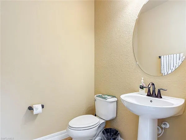 a bathroom with a toilet a sink and mirror