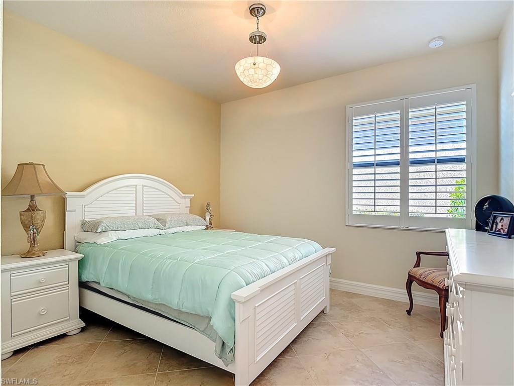 9250 Veneto Place Naples, FL 34113 - Photo 30 of 50 a bedroom with a bed and a table
