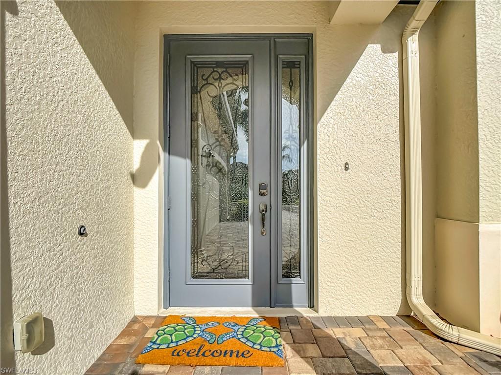 9250 Veneto Place Naples, FL 34113 - Photo 3 of 50 a view of a hallway with wooden floor and a bathroom