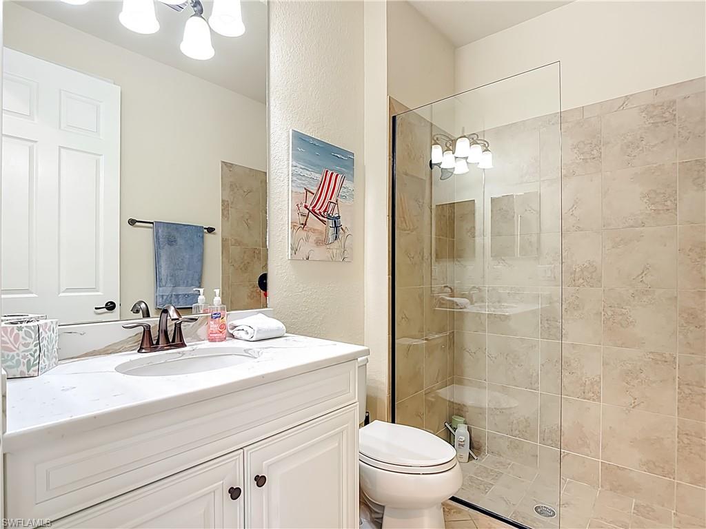 9250 Veneto Place Naples, FL 34113 - Photo 32 of 50 a bathroom with a sink a toilet a shower and a mirror