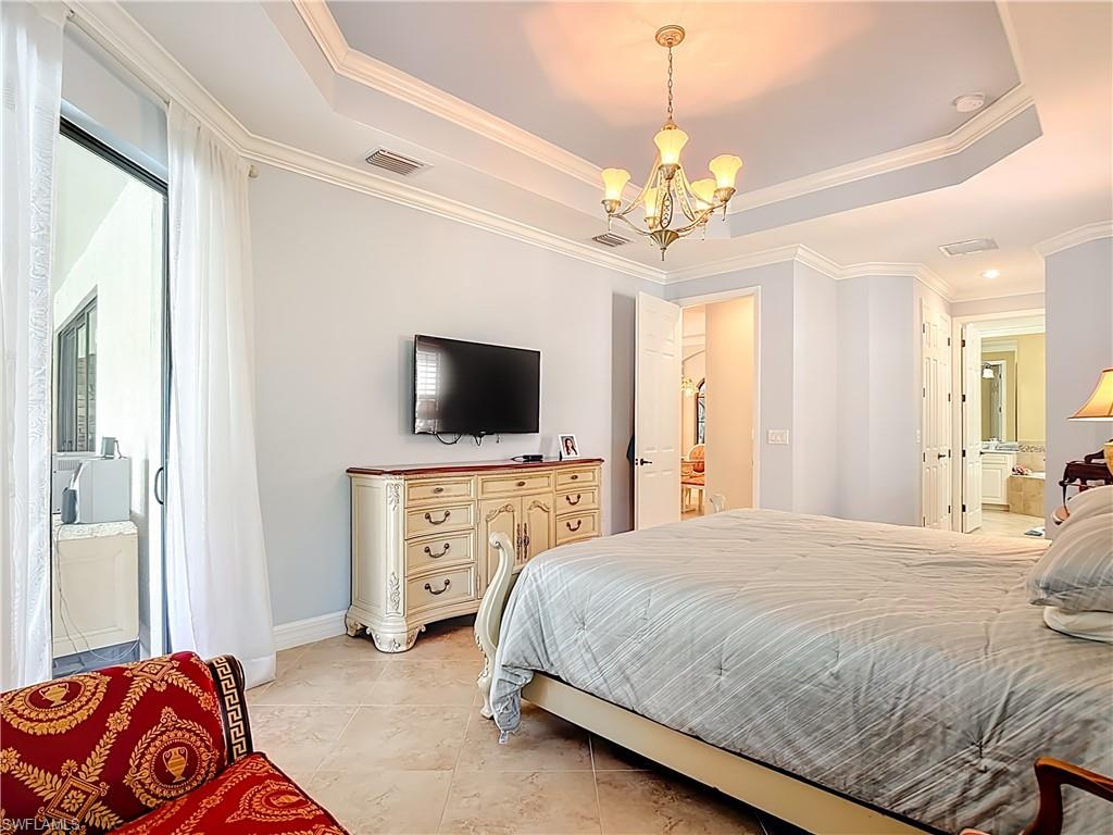 9250 Veneto Place Naples, FL 34113 - Photo 33 of 50 a bedroom with a bed and a flat screen tv