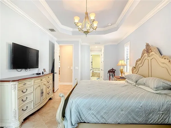 a spacious bedroom with a bed and a flat screen tv