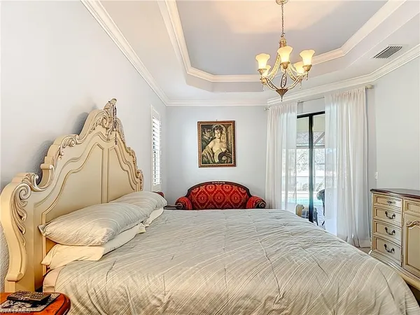 a bedroom with a bed and a chandelier