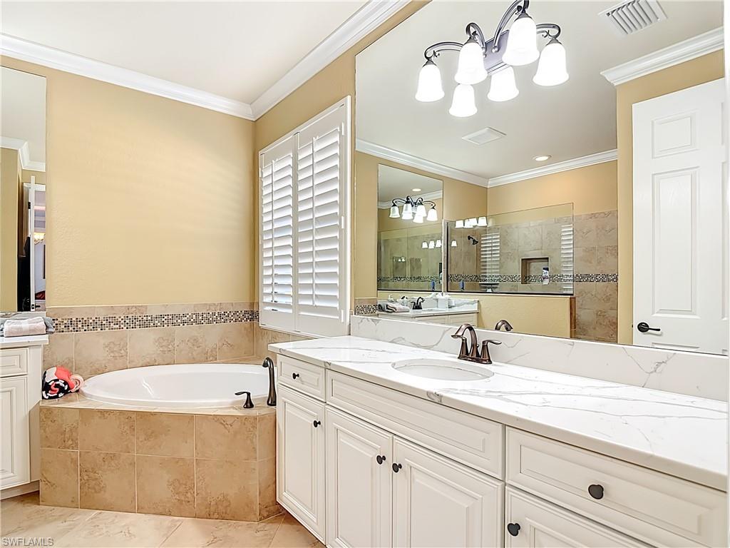 9250 Veneto Place Naples, FL 34113 - Photo 37 of 50 a bathroom with a tub sink and mirror