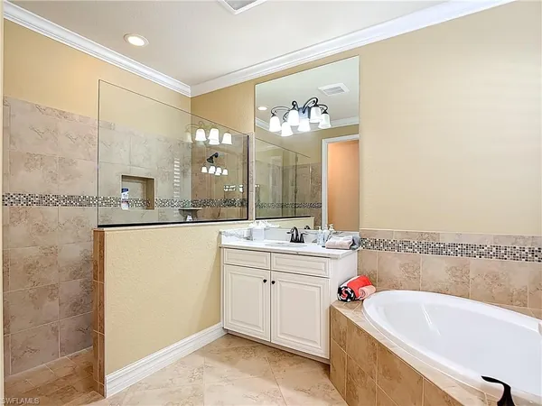 a bathroom with a tub sink and mirror