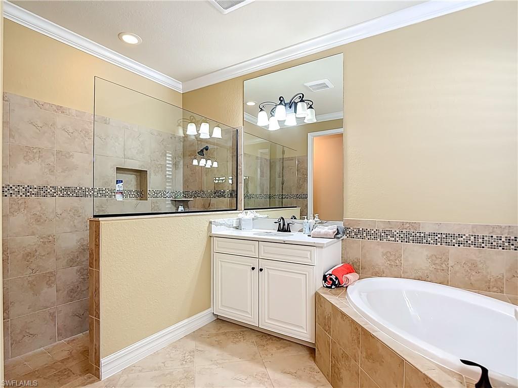 9250 Veneto Place Naples, FL 34113 - Photo 39 of 50 a bathroom with a tub sink and mirror