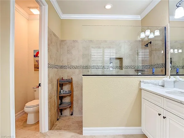 a bathroom with a granite countertop sink a toilet and a mirror
