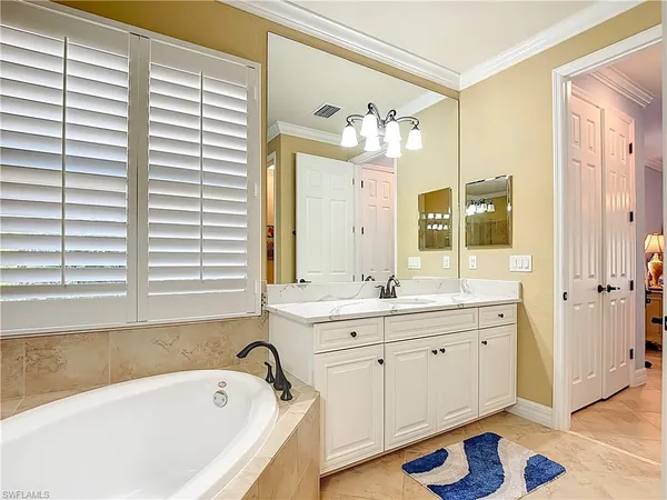a spacious bathroom with a tub sink and mirror