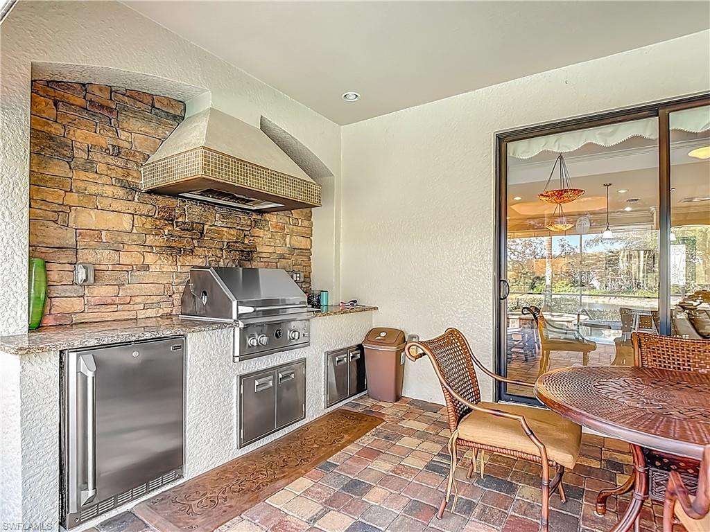 9250 Veneto Place Naples, FL 34113 - Photo 45 of 50 a kitchen with a stove a sink and chairs