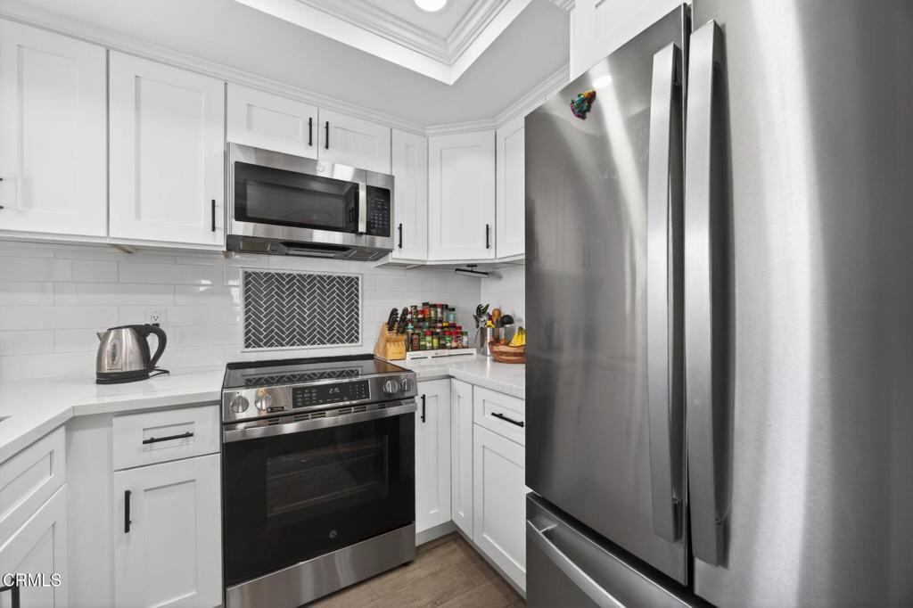 2955 Harbor Boulevard Oxnard, CA 93035 - Photo 16 of 41 a kitchen with stainless steel appliances granite countertop a refrigerator stove and white cabinets