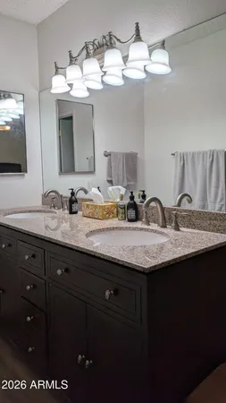 a bathroom with a granite countertop sink a large mirror and shower