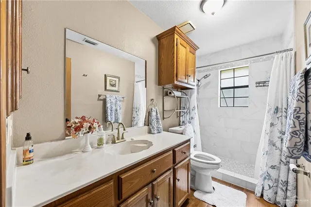 a bathroom with a sink toilet double vanity and shower
