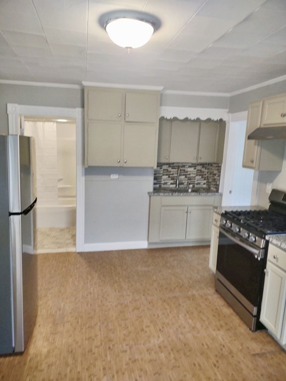 31 Edwards Street, Unit 2F Fitchburg, MA 01420 - Photo 2 of 5 a kitchen with granite countertop a stove and a refrigerator