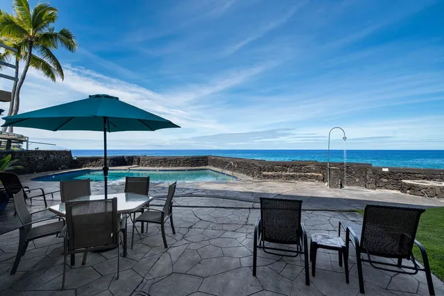a patio with a table and chairs under an umbrella