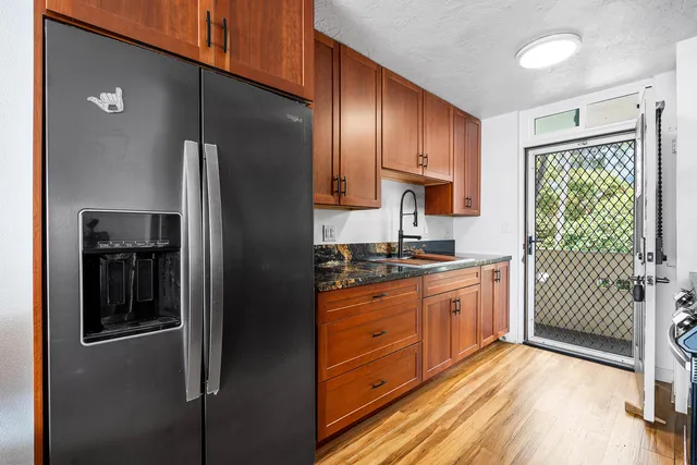 a kitchen with stainless steel appliances granite countertop a refrigerator and a sink