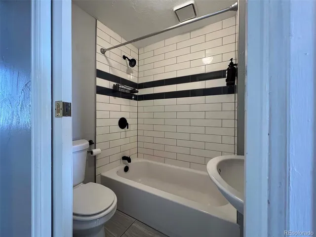 a bathroom with a shower a toilet and bathtub