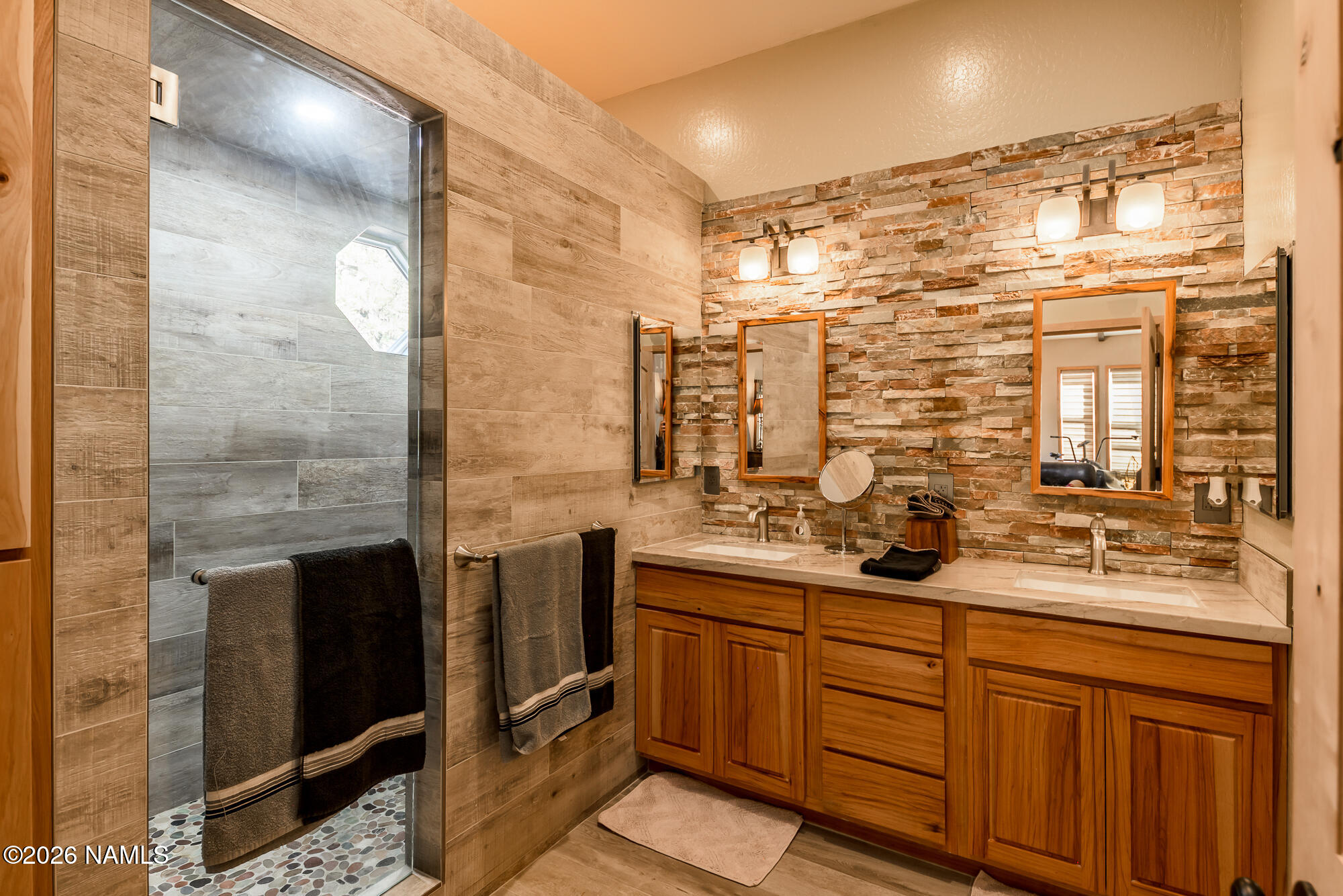 7042 East Robin Hood Road Williams, AZ 86046 - Photo 15 of 58 a bathroom with a double vanity sink a mirror and shower