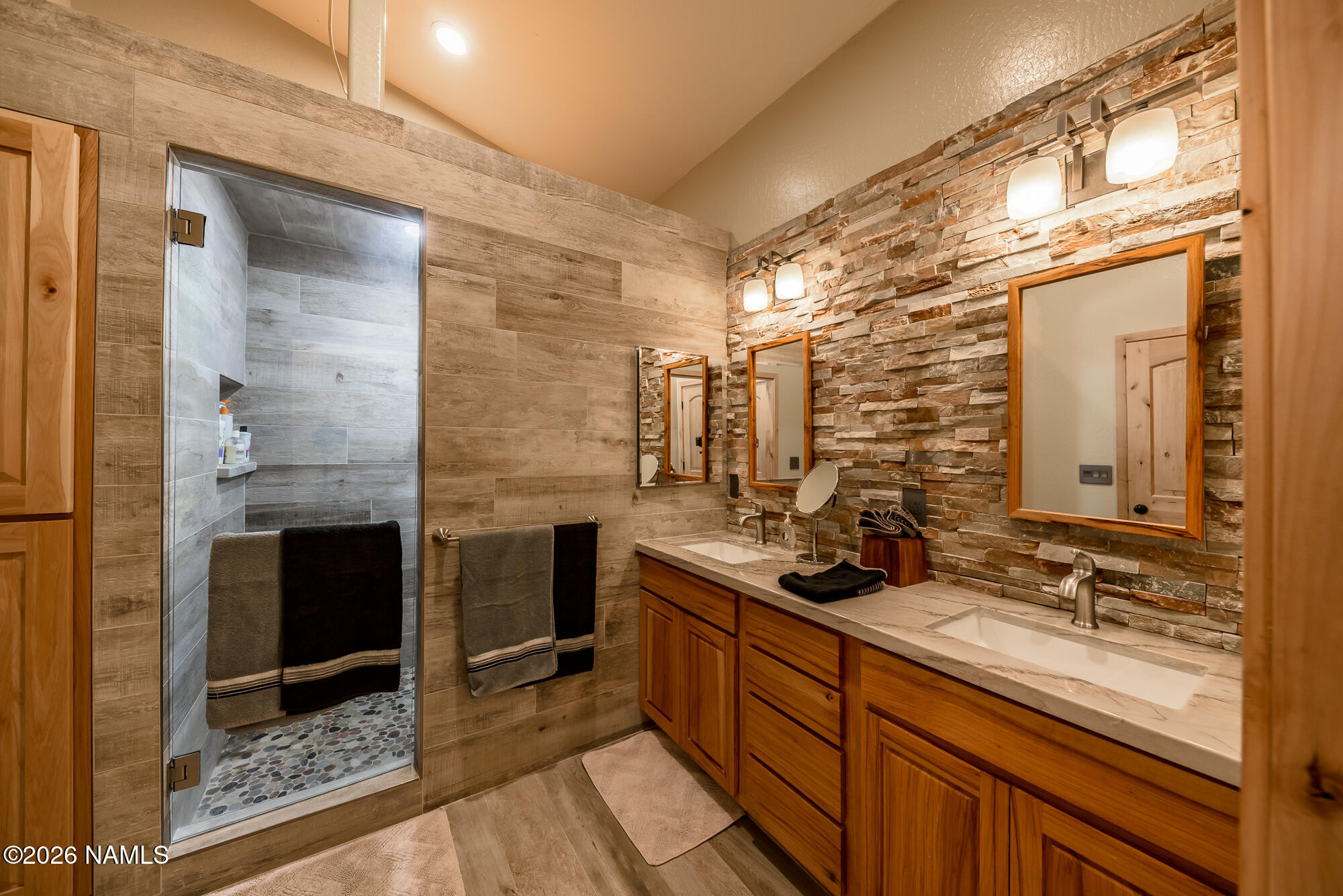 7042 East Robin Hood Road Williams, AZ 86046 - Photo 16 of 58 a bathroom with a double vanity sink a mirror and a shower