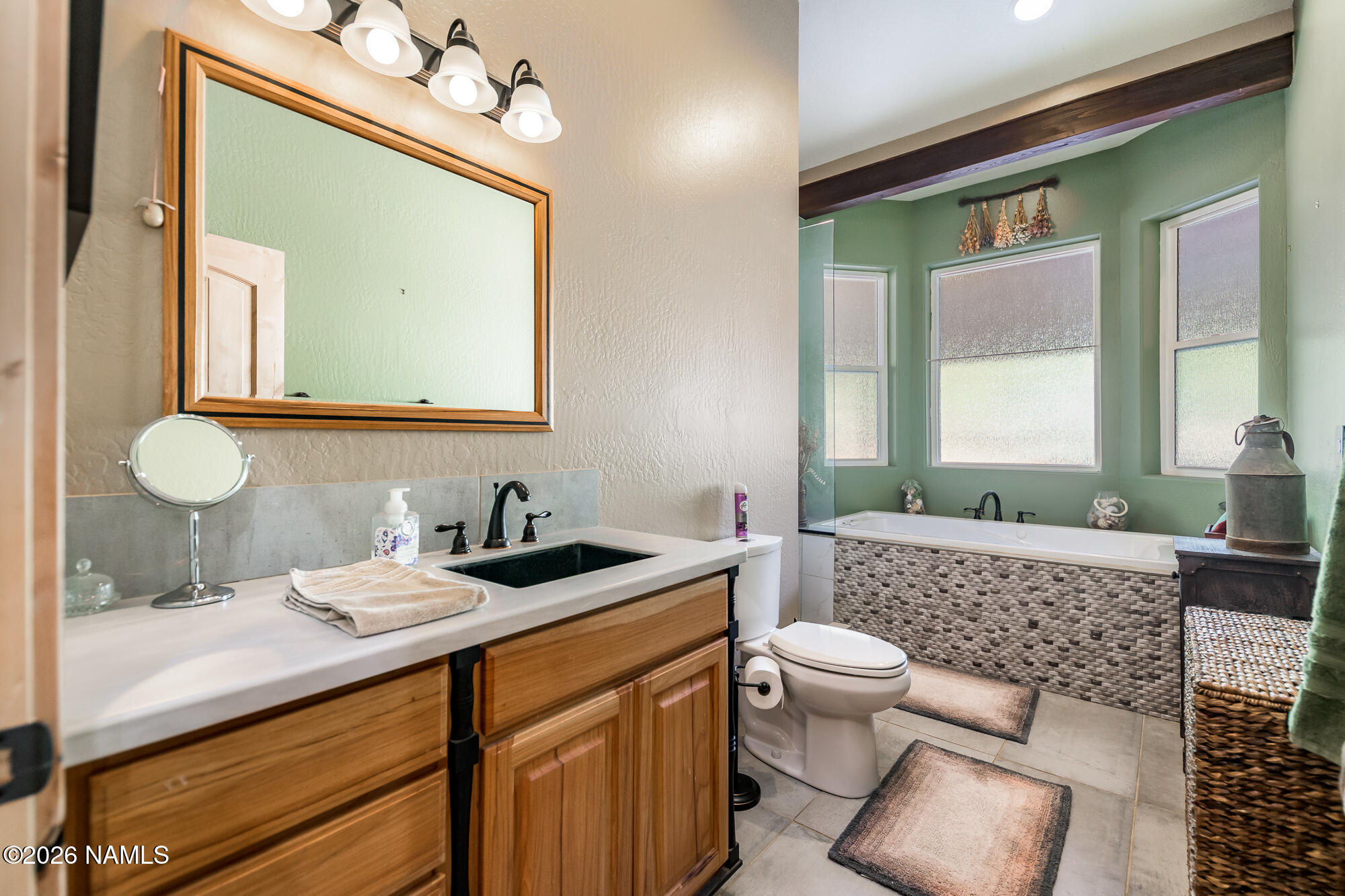 7042 East Robin Hood Road Williams, AZ 86046 - Photo 21 of 58 a bathroom with a toilet a sink a mirror a window and vanity