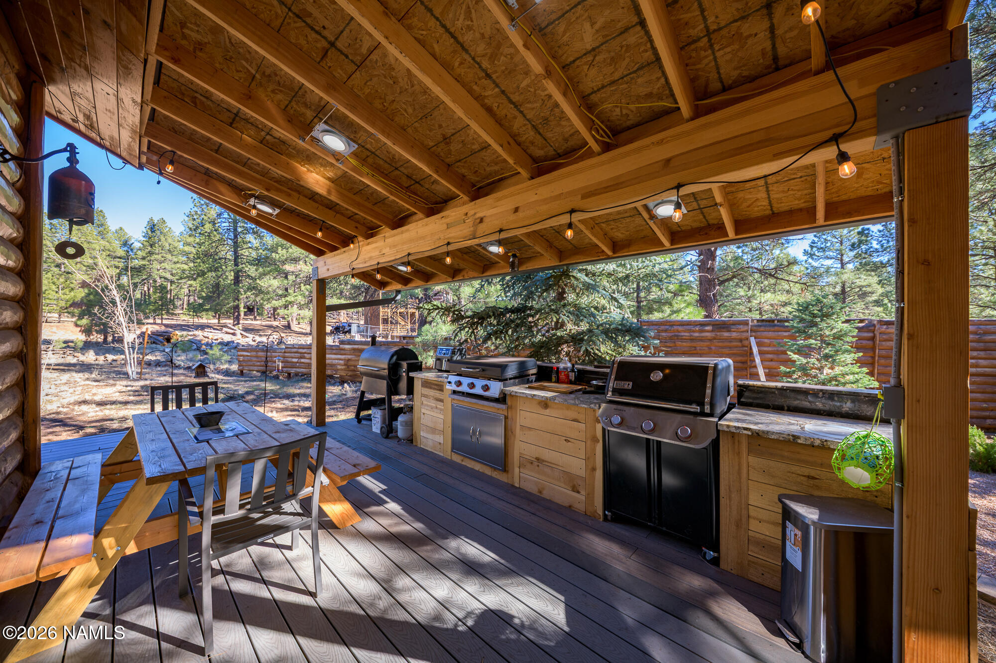 7042 East Robin Hood Road Williams, AZ 86046 - Photo 29 of 58 a view of a chairs and table in a patio with a wooden fence