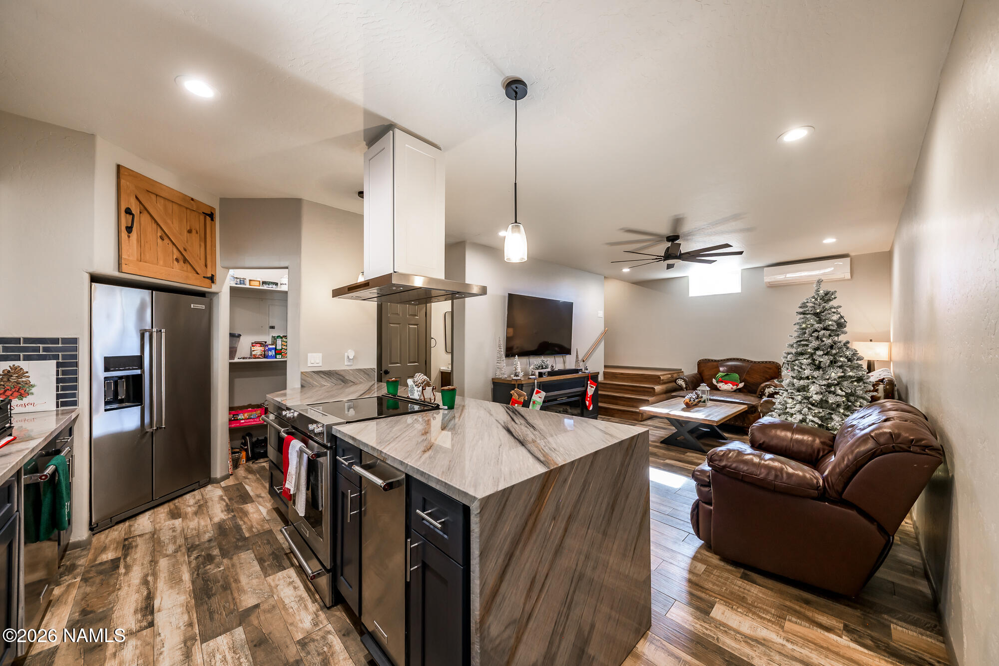 7042 East Robin Hood Road Williams, AZ 86046 - Photo 36 of 58 a living room with stainless steel appliances kitchen island granite countertop furniture a rug a fireplace and a projector