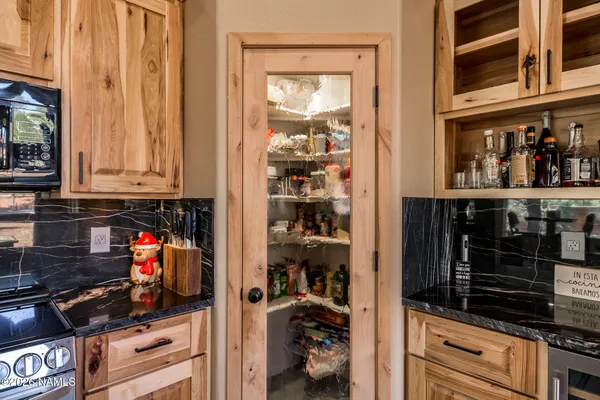 a dining room with stainless steel appliances granite countertop a table chairs and a living room