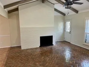 an empty room with a ceiling fan and window