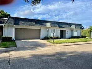 a front view of a house with a garden and garage