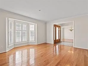 a view of an empty room with glass door and wooden floor