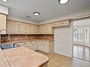 a kitchen with granite countertop a refrigerator sink and cabinets
