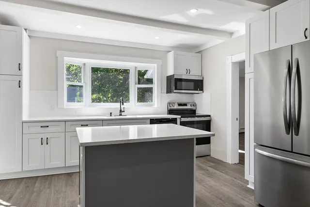 a kitchen with stainless steel appliances granite countertop a sink stove and refrigerator