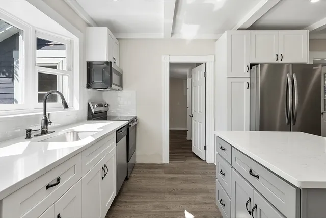 a kitchen with a sink appliances and cabinets