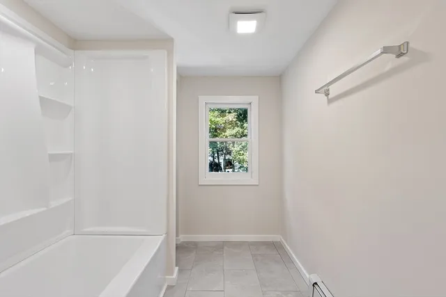 a view of bathroom with bathtub and window