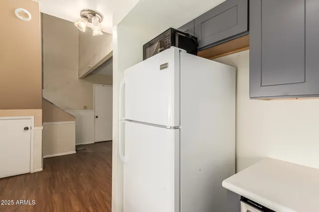 a view of wooden floor and a chandelier fan in a room