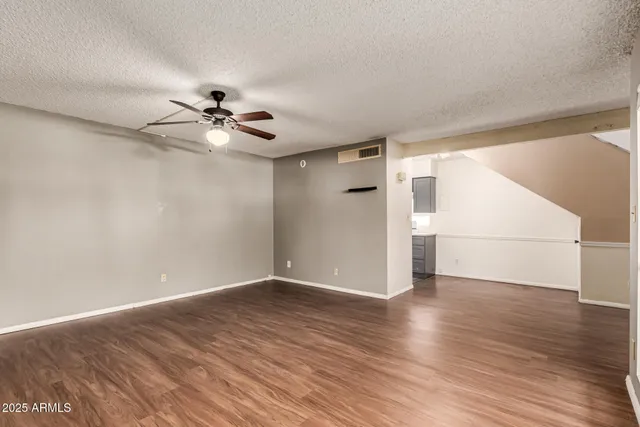 a view of a room with wooden floor and a ceiling fan