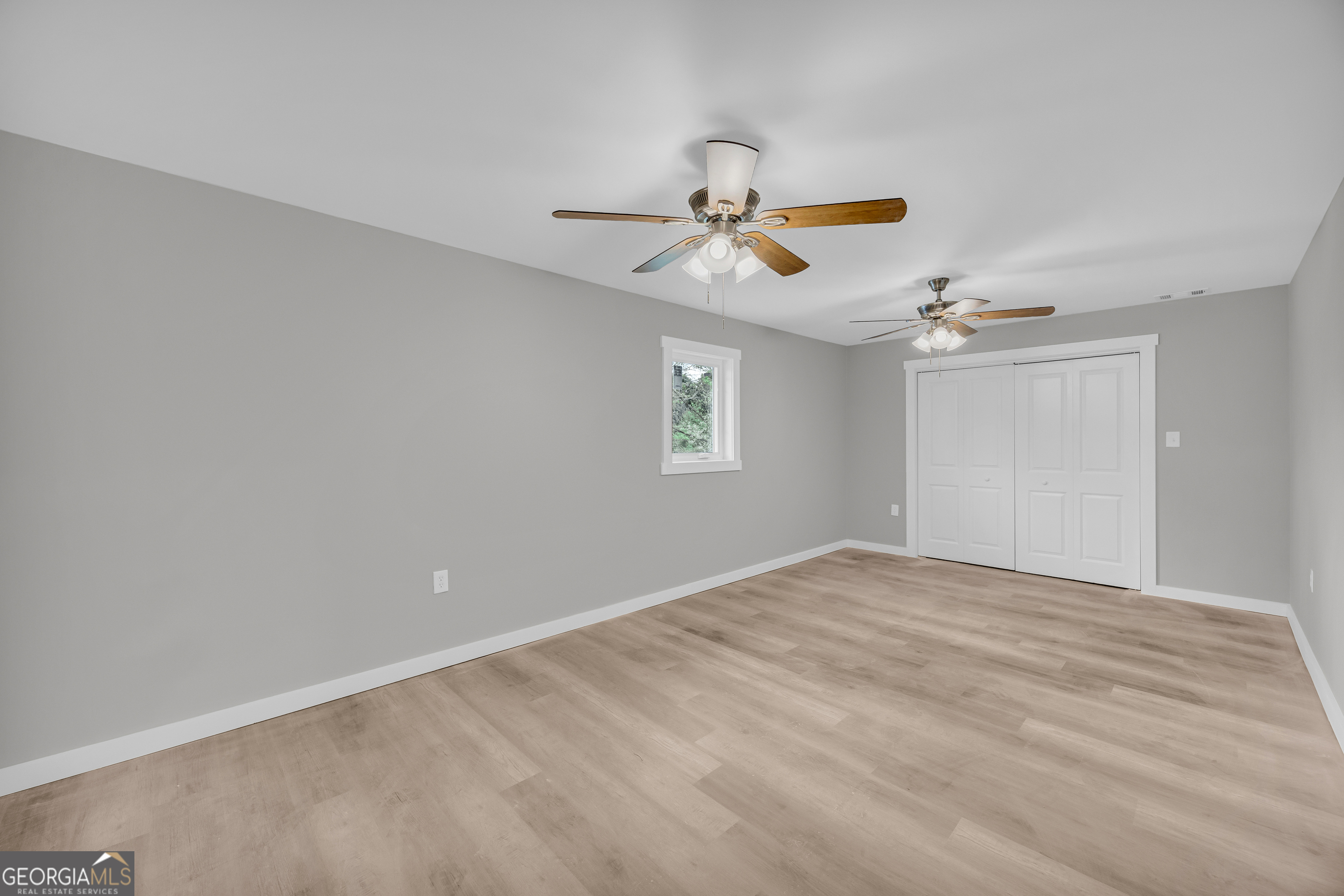 8606 Holly Springs Road Maysville, GA 30558 - Photo 57 of 74 a view of empty room with window and ceiling fan