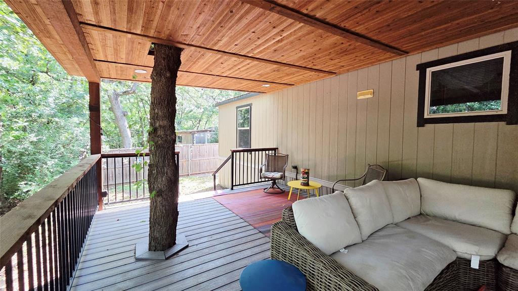 45 Bravo Road Pottsboro, TX 75076 - Photo 5 of 40 Expansive covered deck featuring a natural tree support, wood-finish ceiling, composite decking, and black metal railings