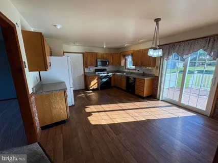 a open kitchen with refrigerator stove and wooden floor