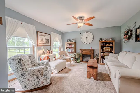 a living room with furniture a fireplace and a large window