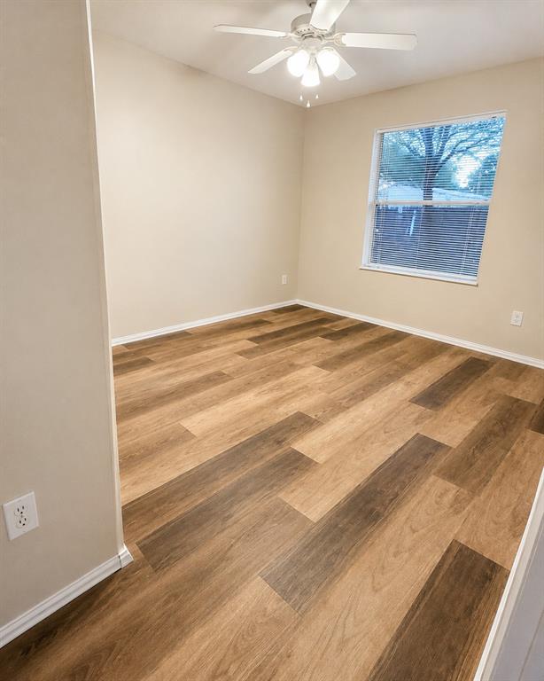 9455 Tranquil Acres Road Fort Worth, TX 76179 - Photo 7 of 20 Spacious room featuring wood-finish flooring, neutral-toned walls, and a white ceiling fan with integrated lighting