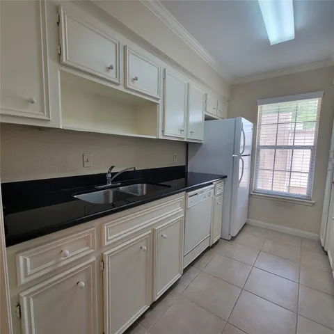 a kitchen with granite countertop white cabinets and stainless steel appliances