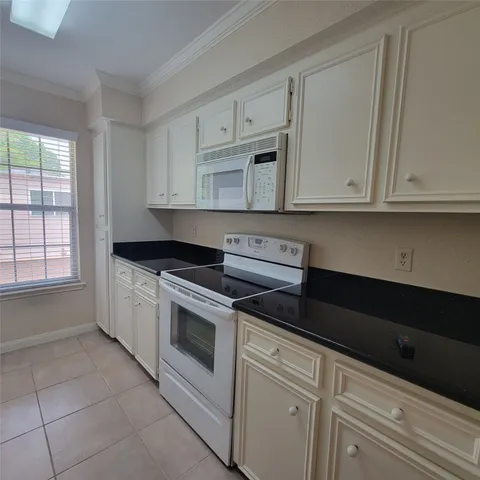 a kitchen with granite countertop white cabinets and sink