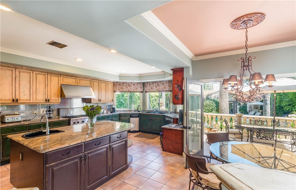 15237 Sutton Street Sherman Oaks, CA 91403 - Photo 7 of 31 a kitchen with a stove a sink a counter top space and living room filled with furniture