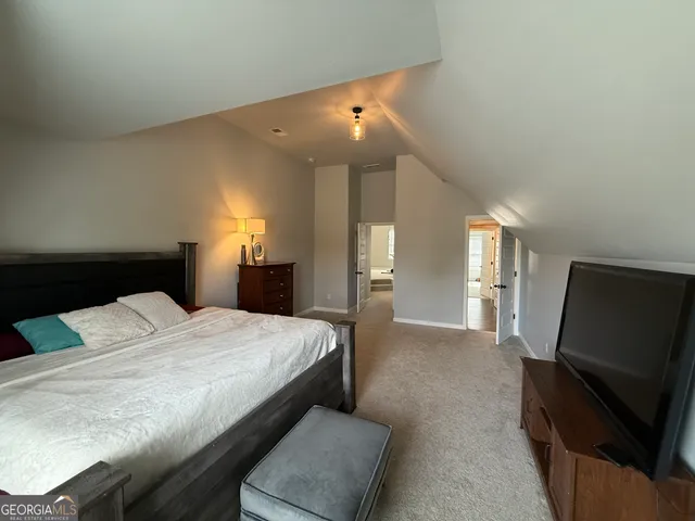 a view of a hallway with a livingroom and a bathroom with sink