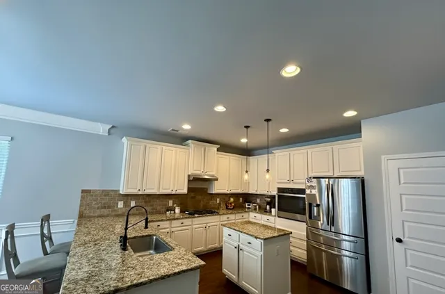 a dining room with wooden floor a chandelier a wooden table and chairs