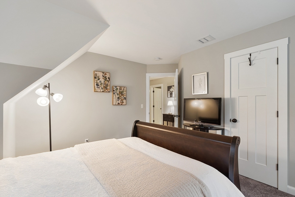 23 Calla Road Londonderry, NH 03053 - Photo 23 of 37 a bedroom with a bed and a flat screen tv