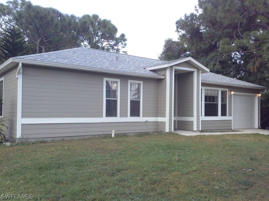 9099 Henry Road Fort Myers, FL 33967 - Photo 1 of 10 a front view of a house with a garden