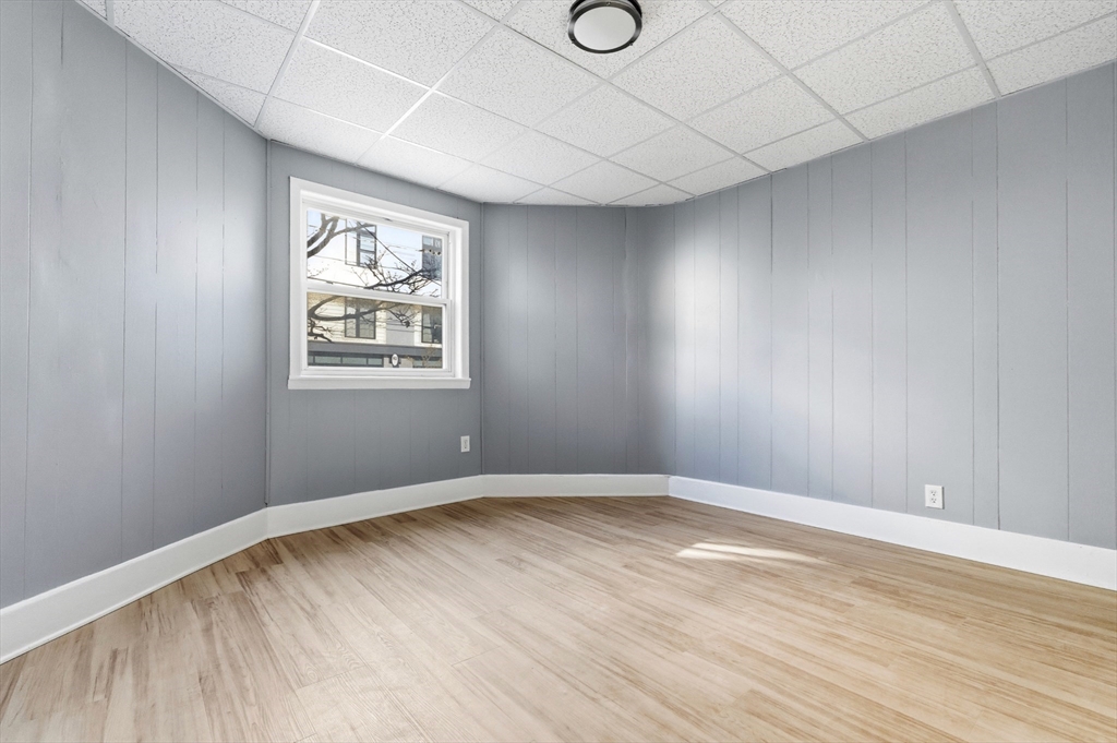204 Washington Street, Unit 1 Somerville, MA 02143 - Photo 5 of 19 an empty room with wooden floor and windows