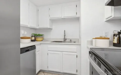a kitchen with white cabinets and appliances